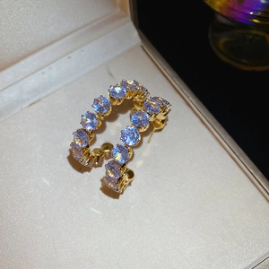 Macro shot of gold-plated hoop earrings with sparkling clear cubic zirconia stones