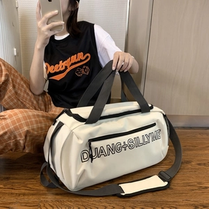 Détail d'un sac de voyage blanc avec des sangles noires et lettrage du logo