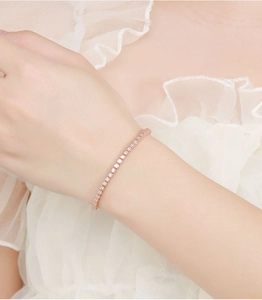 Close-up of a minimalist 2mm rose gold moissanite bracelet worn on a woman's wrist
