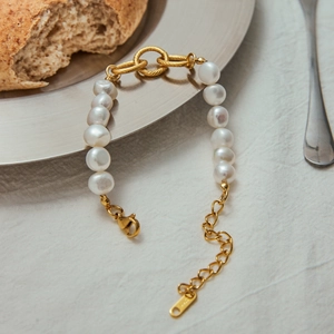 Detailed macro view of 18k gold-plated pearl bracelet with S925 silver clasp and heart charm
