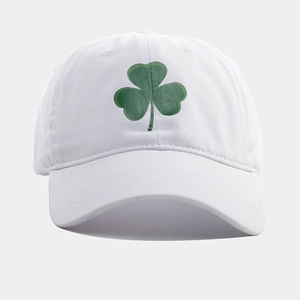 Dettaglio del cappellino bianco lavato con ricamo a quadrifoglio verde e cuciture precise