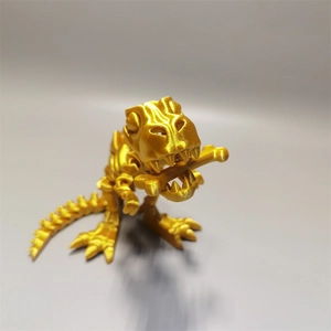 Macro shot of 3D printed golden T-Rex skeleton model holding a bone in its mouth