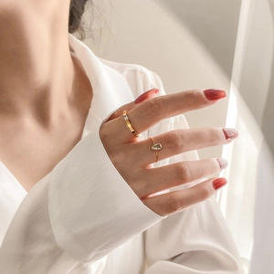 Detailed close-up of a gold waterdrop rhinestone ring and geometric band on fingers