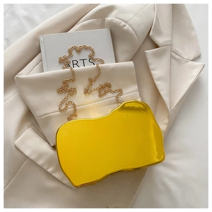 Close-up of golden irregular wavy evening clutch with metallic mirror finish and chain strap