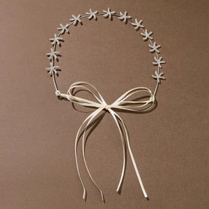 Close-up of a silver starfish bridal headband with crystals and cream ribbon tie