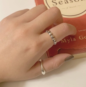 Detailed view of two minimalist 925 sterling silver rings worn on a model's hand