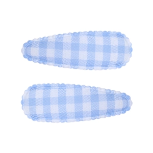 Détail de barrettes à carreaux vichy bleu et blanc avec bords festonnés décoratifs