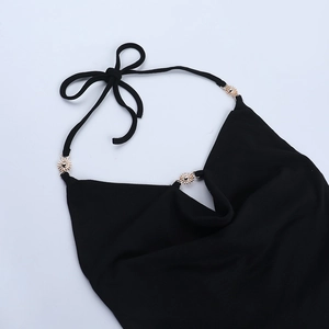 Detail of black halter top with gold sunburst metal buckle and neck tie closure