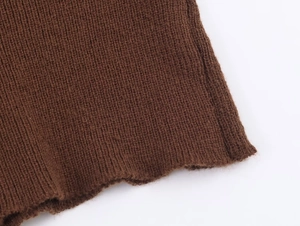 Macro view of caramel brown knit sweater featuring detailed ribbed texture and soft fabric