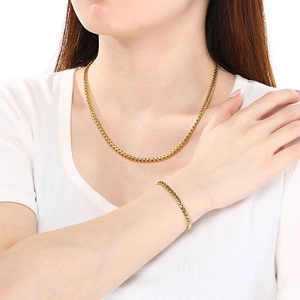 Golden wheat chain jewelry set including necklace and bracelet worn by female model