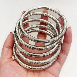Set of silver stainless steel bangles featuring polished, spiral, and textured patterns