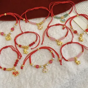 Bracelet tressé en cordon rouge avec breloques cheval dorées et perles en cristal