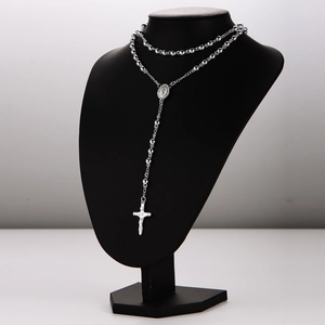 Silver rosary necklace with cross pendant and beaded chain on a black mannequin