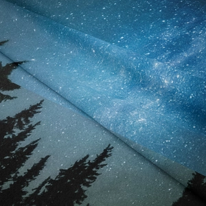 Dettaglio di un arazzo vellutato con foresta e stelle che mostra trama e finiture