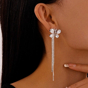 Detail of silver long tassel butterfly earrings with zircon inlay on female model