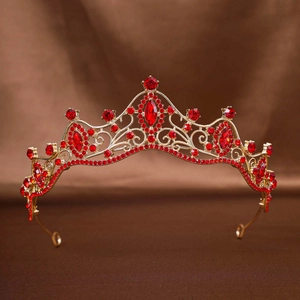 Close-up of golden bridal tiara with vibrant red rhinestones and intricate scrollwork