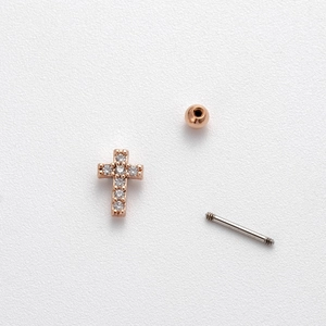 Detail of rose gold cross cartilage stud earring with cubic zirconia and screw ball back