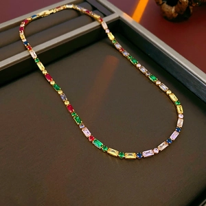 Detailed close-up of a gold tennis necklace with vibrant multicolor rectangular zircons