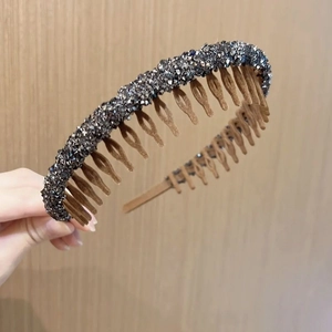 Detail of non-slip headband with dark gray rhinestones and brown teeth comb for secure grip