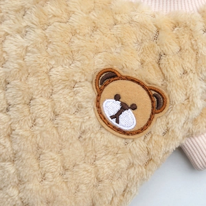 Dettaglio di vestiti in pile sherpa per animali con toppa ricamata a forma di orsetto