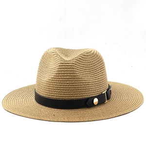 Detail of light brown woven straw Panama hat with black leather band and gold studs