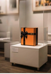 Luxury orange and black gift box with a silk heart-patterned bow for scarves and shawls