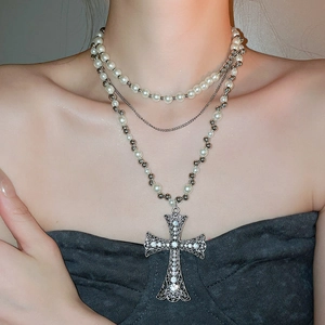 Detail of layered pearl necklace with a vintage silver rhinestone cross pendant
