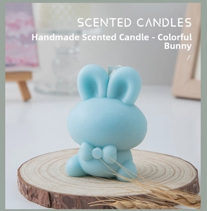 Detail of light blue bunny scented candle with bow on a wooden base for home decor