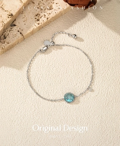 Gros plan d'un bracelet en argent S925 avec gemme bleu clair et petit diamant brillant