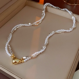 Detail of double-layer necklace with pearls, silver beads and gold heart magnetic clasp