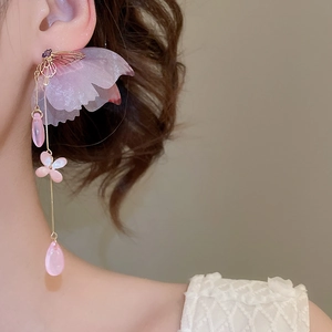 Macro view of pink tassel butterfly earrings with translucent petals and golden frame
