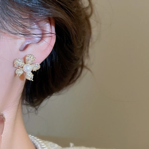 Detailansicht eines Blumen-Perlenohrrings mit Zirkonia-Blütenblättern am Model