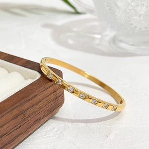 Detailed macro view of a gold plated stainless steel bangle with eight zircon stones
