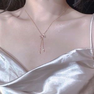 Elegant S925 sterling silver bow necklace in rose gold finish worn by a female model
