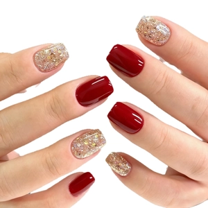 Short square press-on nails in deep red and sparkling gold glitter finish