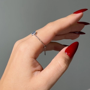 Detailed side view of a silver chain ring featuring a radiant blue rectangular zircon stone