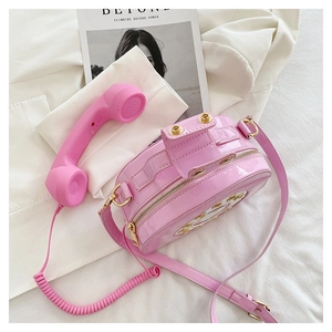 Detail of creative pink telephone handbag with high-gloss finish and rotary dial print
