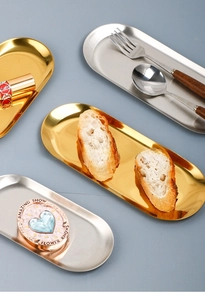 Detailed view of brushed stainless steel oval jewelry trays in gold and silver finishes