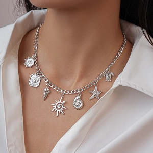 Dettaglio della collana d'argento con ciondoli a conchiglia e stella marina su modella