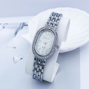 Macro detail of oval quartz watch dial featuring diamond bezel and silver link band