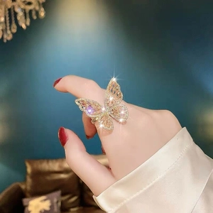 Macro shot of a golden zircon butterfly open ring worn on a finger with sparkling details