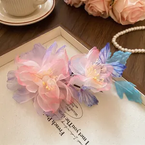 Dettaglio di fermaglio per capelli con fiori in rete rosa e viola con perle e sfumature