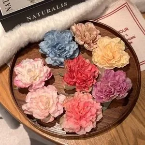 Detail showing variety of colorful silk peony flower heads on elegant wooden tray