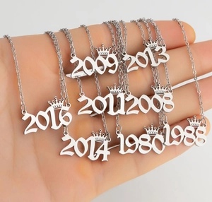 Detail of silver angel number necklaces with crown charms from 1980 to 2016