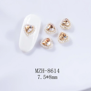 Détail d'un bijou d'ongle cœur champagne avec bordure de perles, taille 7,5x8mm