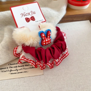 Close-up of plush hair scrunchie with red polka dots and a cute rabbit ornament
