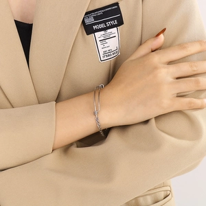 Detail of adjustable silver twisted metal bracelet worn on wrist with minimalist style