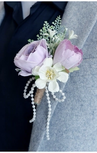 Detail of handmade purple rose boutonniere with faux pearls on a grey tweed suit lapel