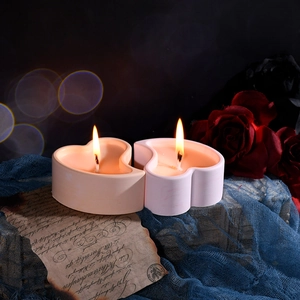 Paar brandende hartvormige geurkaarsen in een romantische vintage setting met rozen
