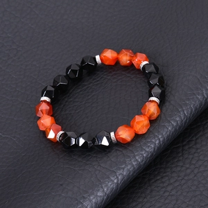 Close-up of faceted black obsidian and orange agate beaded stretch bracelet on leather
